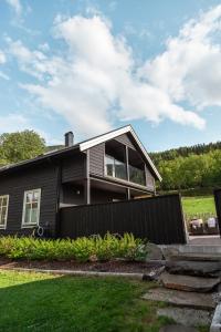 ViksdalenTuftegarden的前面有栅栏的黑色房子