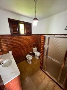 彼得罗波利斯Chale das hortensias的浴室配有卫生间、盥洗盆和淋浴。