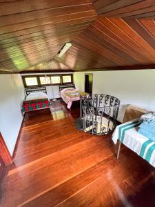彼得罗波利斯Chale das hortensias的客房设有两张床,铺有木地板。