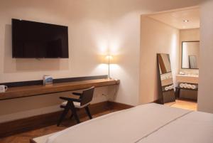 Cuatrociénegas de CarranzaHotel Marielena的酒店客房设有一张桌子和一台墙上的电视