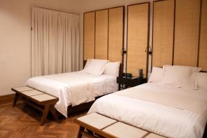 Cuatrociénegas de CarranzaHotel Marielena的酒店客房设有两张床和一张桌子。