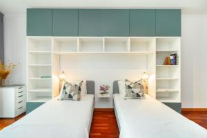 马托西纽什Ocean Front 2bed Luxury w/ Elevator Parking WI-FI的配有白色架子的客房内的两张床