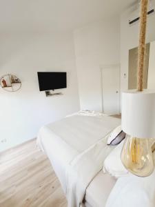 阿吉拉海滩INFINITY VIEW的白色的客房配有床和电视。