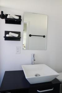 坦帕Mi Casa Es Tu Casa, Airport Suites的浴室设有白色水槽和镜子