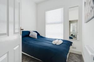 利物浦Dacy Lodge - Anfield Apartments的一间卧室配有蓝色的床和毛巾