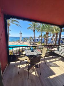 阿吉拉海滩INFINITY VIEW的海滩景阳台配有桌椅