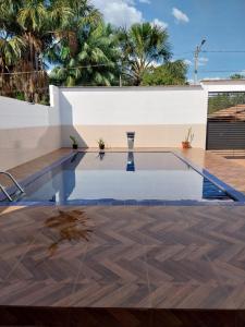 托坎廷斯州蓬蒂阿尔塔Pousada JF tour的棕榈树房子里的一个空游泳池