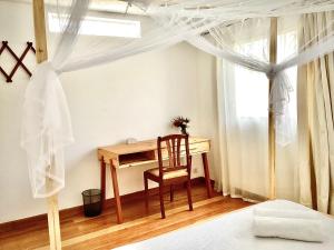塔那那利佛Villa ChezSoa, Antananarivo的一间卧室配有桌子、椅子和窗户