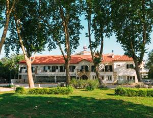 托马尔Estalagem Santa Iria Hotel & Spa的前面有大量树木的建筑