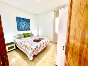 罗萨里奥港Little Home的一间卧室配有一张带彩色床罩的床