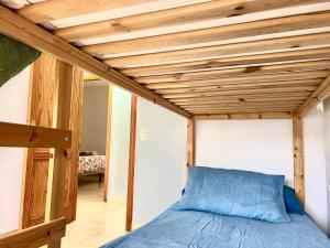 罗萨里奥港Little Home的木天花板的客房内的一张床位