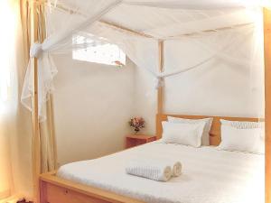 塔那那利佛Villa ChezSoa, Antananarivo的卧室配有带白色床单的天蓬床