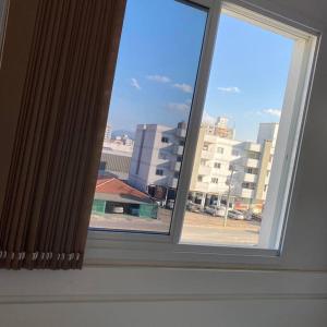 布吕斯克Quarto solteiro em brusque的享有城市美景的开放式窗户。