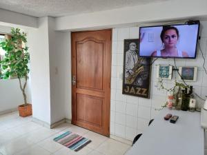 马尼萨莱斯Apartamento Central En La Zona De Cable Plaza的一间设有门的房间和墙上的电视