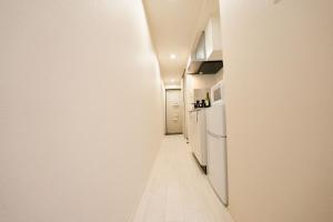 东京FL Rejidence Shinjuku 2 - Vacation STAY 15187的走廊设有白色墙壁和白色冰箱