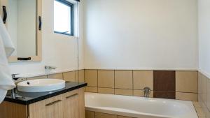 SandtonLush Studio Apartment with Back-Up Power.的浴室配有盥洗盆和浴缸。