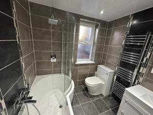 利物浦3 Bedroom House on Beatles Famous Road的带浴缸和卫生间的浴室。