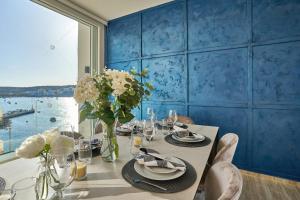 圣保罗湾城Lux Villa with Pool-Hosted by Sweetstay的一间设有一张桌子和蓝色墙壁的用餐室