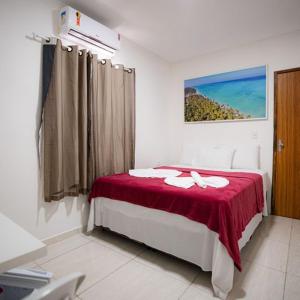 马拉戈日Pousada Villa Costeira的一间卧室配有一张带红色毯子的床