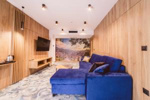 萨拉热窝Hotel Boutique Anoma的客厅配有蓝色的沙发和电视
