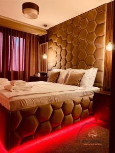 潘波洛沃Deluxe Apartment 33 Mountain Lodge Pamporovo的一间卧室配有一张红色灯大床