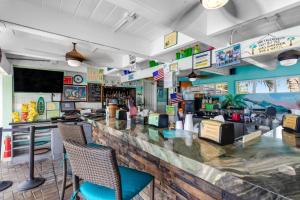 基克罗尼海滩Coastal Charm Hideaway的餐厅内的酒吧配有椅子和柜台