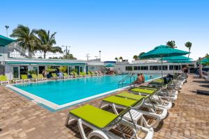基克罗尼海滩Breezy Palms & Tropical Charm的一个带躺椅和遮阳伞的游泳池