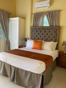 尼格瑞尔Runthings Hideaway Stay Negril的一间卧室配有一张带橙色和白色枕头的大床