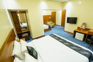 达卡里士满套房酒店的酒店客房设有一张大床和一台电视。