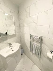 清福德London Studio的白色的浴室设有水槽和镜子