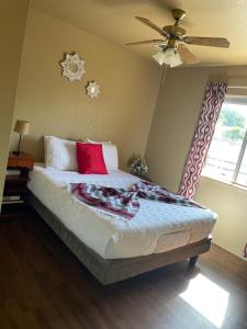 卡顿伍德All season vacation home!的一间卧室配有一张带红色枕头的床和吊扇