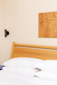 费城YOWIE Hotel的一张带木制床头板和白色枕头的床