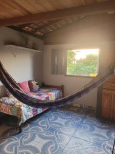 索雷Hospedagem Casinha do Solar的一张吊床,位于带床和窗户的房间