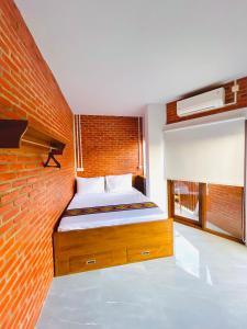 纳闽巴霍Puu Pau Hotel & Coffee Shop的一间卧室配有一张砖墙床