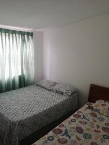 JamundíCasa la Alborada的一间小卧室,配有两张床和窗户