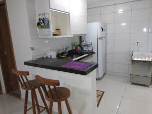 维拉维尔哈Casa da Bia apto 01 - apto inteiro的厨房配有2把吧台凳和1台冰箱