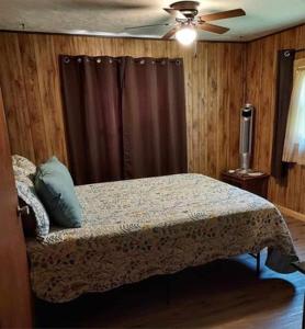 奇夫兰Sandie's Country Bed and Bath的一间卧室配有一张床和吊扇
