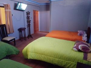 科帕卡巴纳Wayky's Club and Hostal的一间卧室配有两张床和一台平面电视