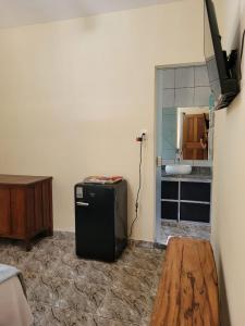 皮雷诺波利斯Suítes Boa Viagem的一间位于客房角落的带冰箱的房间
