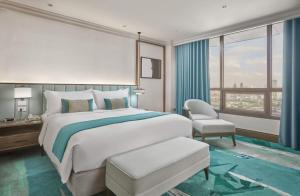 马尼拉Holiday Inn Manila Galleria, an IHG Hotel的卧室配有床、椅子和窗户。