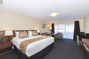 罗托鲁瓦Newina Rotorua的酒店客房设有一张大床和一张书桌。
