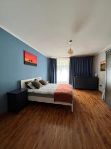 乌兰巴托Location, locaton, location!的一间卧室配有一张蓝色墙壁和木地板。