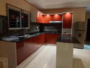 LelydorpA&N appartementen的一间带红色橱柜和冰箱的厨房