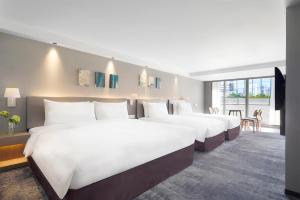 台北ILLUME 茹曦酒店的一间酒店客房,设有两张床和电视