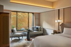 京都Dusit Thani Kyoto的酒店的客房 - 带一张床、椅子和窗户