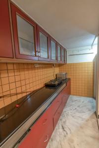 班加罗尔HomeSlice Yellow的一间厨房,配有红色橱柜和台面