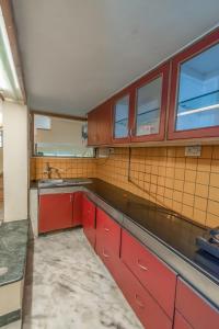 班加罗尔HomeSlice Yellow的一间带红色橱柜和水槽的厨房