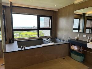 头城幸福M&M House-龜山日出溫泉景觀宅的带浴缸的浴室和大窗户