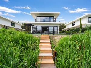 泽沃德Cosy, modern family villa up to 6p in Flevoland in a wonderful environment的通往高草屋的通道