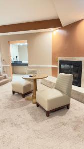 哈里斯堡Inn of the Dove - Romantic Luxury Suites with Jacuzzi & Fireplace at Harrisburg-Hershey-Philadelphia, PA的客厅配有桌椅和壁炉